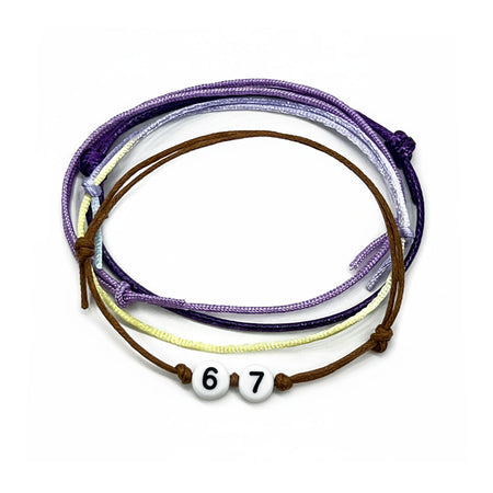 A layered set of Purple 67 bracelets featuring adjustable waterproof string cords in lavender, pastel yellow, deep purple and brown with white number beads reading ‘67.’ This aesthetic meme bracelet pack is inspired by the viral 6-7 hand gesture trend and worn as playful 67 jewelry for teens, best friends and Gen Alpha TikTok fans.
