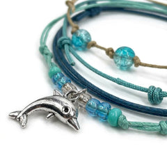 Close-up of the silver-tone dolphin charm with seafoam, aqua and clear beads on the Green Dolphin Bracelet Style Pack