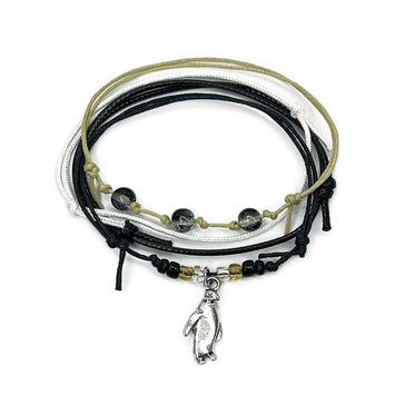 Penguin Bracelet Style Pack – 4 stackable charm bracelets with black-and-white tones, shimmer beads and a silver penguin charm. Chill, cute and giftable.