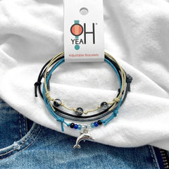 Black Dolphin Bracelet Style Pack on its O Yeah adjustable bracelet card, laid on a white tee and denim