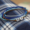Blue and aqua 67 bracelet pack from O Yeah Gifts arranged in a circle on a cozy plaid blanket, flat lay jewelry image and trend jewelry photography showing a soft coastal fashion vibe, 6-7 meme bracelet and six seven slang jewelry for teens who want a cute 67 trend bracelet and friendship bracelet gift after googling what is 6 7 or what does 67