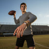 Teen quarterback on a football field at sunset, mid-throw with a brown and gold 67 bracelet stack from O Yeah Gifts on his wrist, athletic 6-7 meme bracelet and six seven meme jewelry that nods to the 6-7 TikTok trend and Mr 6-7 Taylen Kinney energy, gen alpha 6-7 slang IYKYK accessory, 67 trend bracelet as school safe bracelet and viral gen alpha accessory, six seven funny gift and 6-7 meme merchandise for sports-loving teens who want 67 TikTok jewelry and 67 vibe trending style.