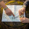 Two kids planning an adventure around a trail map that says “O Yeah!” on a mossy tree stump, one wearing a green 67 bracelet and the other stacked green string bracelets from O Yeah Gifts while they point and hold a compass, lifestyle jewelry image and trend jewelry photography of a 6-7 meme bracelet that makes friends ask “what is 6 7?” and “what does 67 mean?”, perfect 67 trend bracelet and school-safe friendship bracelet gift for outdoorsy gen alpha kids who want an IYKYK six seven meme accessory hiking