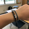 Wrist shot of layered black, gray and brown 67 bracelets with white 6 and 7 beads inside a bright classroom, desks and backpack blurred in the background, school safe bracelet and school friendly accessory from O Yeah Gifts, subtle 6-7 meme bracelet that keeps classmates whispering “what is 6 7?” and “what does 67 mean?” between periods, six seven meme jewelry and gen alpha 6-7 slang accessory, 67 trend bracelet, fun fashion jewelry and everyday 6-7 friendship bracelet gift for students.