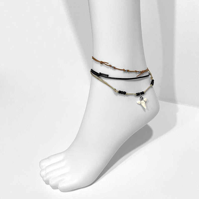 Black shark tooth anklet set on mannequin foot with beaded cords and adjustable slip knots, beach jewelry from O Yeah Gifts for surfers and coastal style
