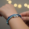 Close-up of a teen’s wrist stacked with blue 67 bracelets resting on a white phone, casual lifestyle jewelry image and ai bracelet photo style of a 6-7 meme bracelet from O Yeah Gifts, great for shoppers searching 6-7 meme bracelet, 67 trend bracelet, what is 6 7 and what does 67 mean as they look for an everyday school-safe accessory.