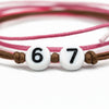 Close-up of the O Yeah Gifts Pink 67 Bracelet Pack showing white number beads reading 67 on brown cord, highlighting the 6-7 meme bracelet trend, six seven slang jewelry and Gen Alpha viral 67 jewelry accessory.
