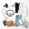 Flat lay of a chic travel outfit with black tank and white button-up shirt, light denim shorts, white sneakers, tan crossbody bag with passport and boarding pass, smartphone, sunglasses, earbuds and coffee cup surrounding a blue evil eye cord bracelet stack from O Yeah Gifts; evil eye bracelet, protective charm jewelry, lifestyle jewelry image, ai jewelry image, ai bracelet photo, product photography jewelry, trend jewelry photography.