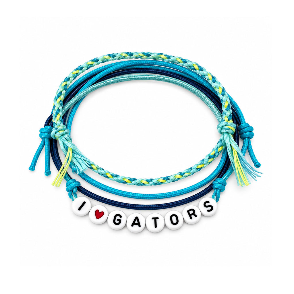 A stack of braided and knotted cord bracelets in shades of blue, teal, and yellow, with a white beaded charm spelling 'I' followed by a red heart and 'GATORS'.