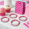 O Yeah Gifts Pink 67 Bracelet Pack displayed as party favors with pink and polka-dot gift bags and cupcakes, featuring pink, white and brown adjustable string cords with white 67 beads. A cute birthday gift for girls and a school-safe 6-7 meme accessory trending as six seven slang jewelry, viral 67 friendship jewelry and a fun teen meme bracelet to buy online.