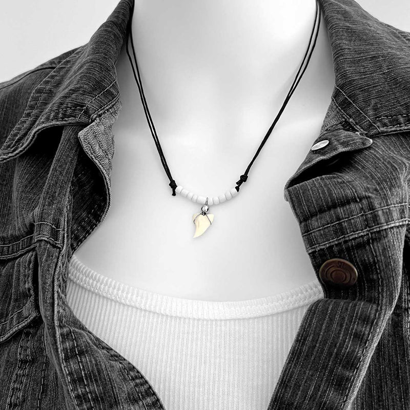 White beaded shark tooth necklace with black cord, unisex surfer necklace featuring real shark tooth pendant, displayed on model with white tank and denim jacket
