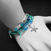 Starfish Charm Bracelet Pack with multistrands stackable beach bracelets with blue beads and starfish charm on a wrist against a dark background