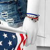 Trump jewelry stack with red, white and blue cords, TRUMP letter beads, silver star charm and accent beads shown on wrist holding an American flag. Patriotic conservative accessory for Trump supporters, MAGA bracelet style perfect for women, teens and rally outfits. Adjustable and stackable for USA pride, Republican gifts and bold America First fashion.