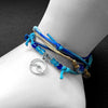 Stackable adjustable wave bracelet with silver wave charm, beaded sea glass accents, and waterproof string cord bracelets in ocean blues from O Yeah Gifts sold wholesale. 