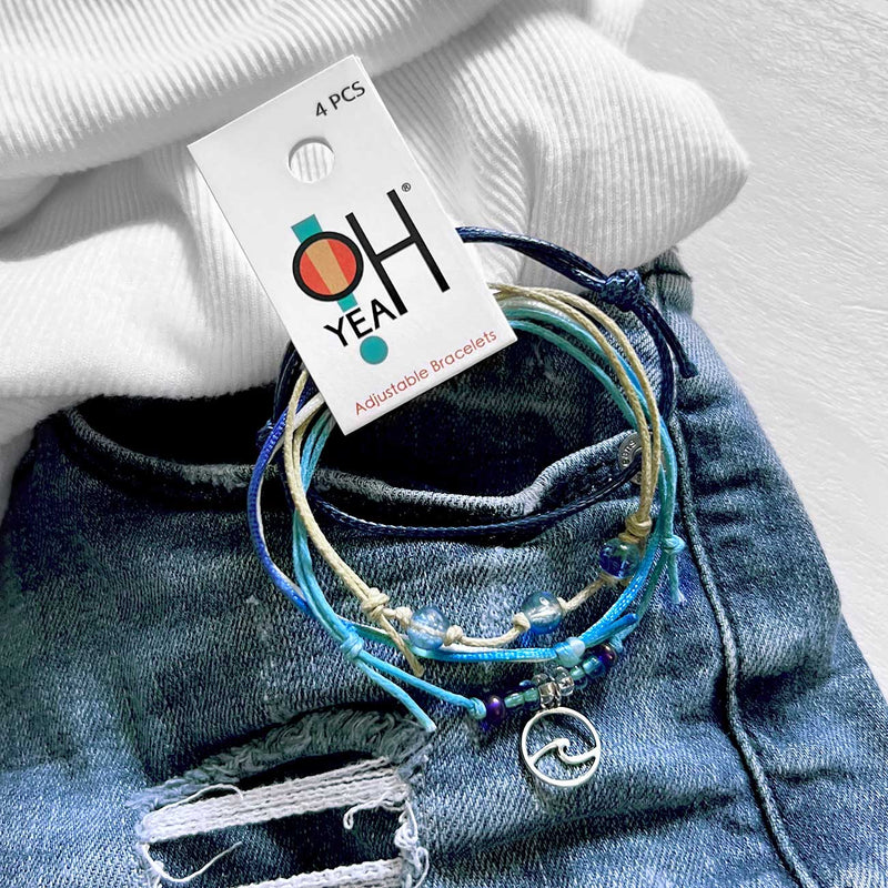 O Yeah Gifts 4-piece Wave Charm Bracelet Pack with adjustable string cords, beaded bracelets and silver wave charm styled on denim and white knitwear made by O Yeah Gifts