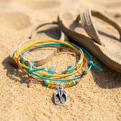 Flip Flop Bracelet Style Pack in a summer vacation still life, the silver-tone flip flop charm in view.
