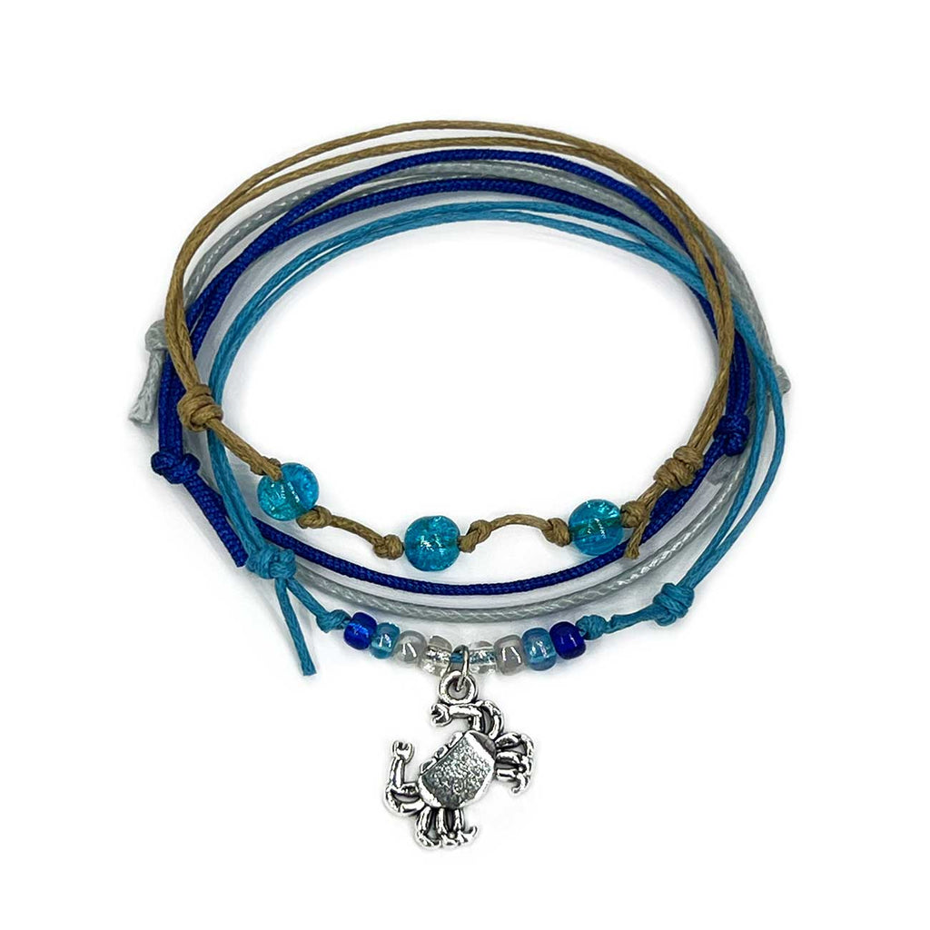 Crab Bracelet Style Pack: 4 blue, gray and beige bracelets with a silver-tone crab charm, flat lay on white
