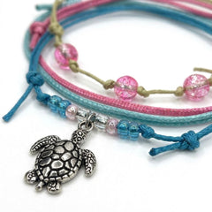 Close-up of the silver-tone sea turtle charm with pink and blue glass beads on the Sea Turtle Bracelet Style Pack Pink.