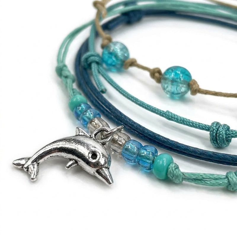 Close-up of the silver-tone dolphin charm with seafoam, aqua and clear beads on the Green Dolphin Bracelet Style Pack