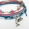 Close-up of the silver dolphin charm and pink and blue glass beads on the Dolphin Bracelet Style Pack Pink.