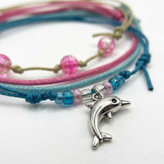 Close-up of the silver dolphin charm and pink and blue glass beads on the Dolphin Bracelet Style Pack Pink.
