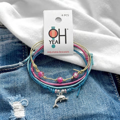 Dolphin Bracelet Style Pack Pink on its O Yeah four-piece hang tag, laid on denim and a white tee.