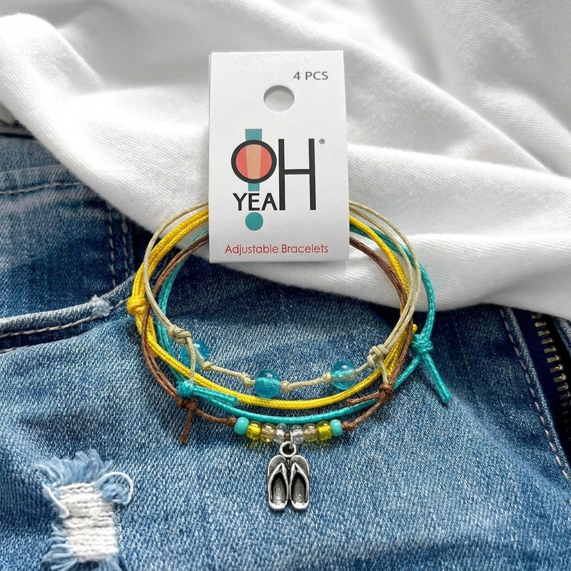 Flip Flop Bracelet Style Pack on its O Yeah four-piece hang tag, laid on denim and a white tee.
