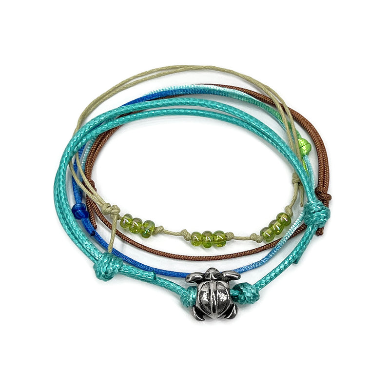 Green sea turtle bead bracelet with an adjustable string design, featuring a silver sea turtle charm and pink bead accents, perfect for ocean lovers and beach enthusiasts.