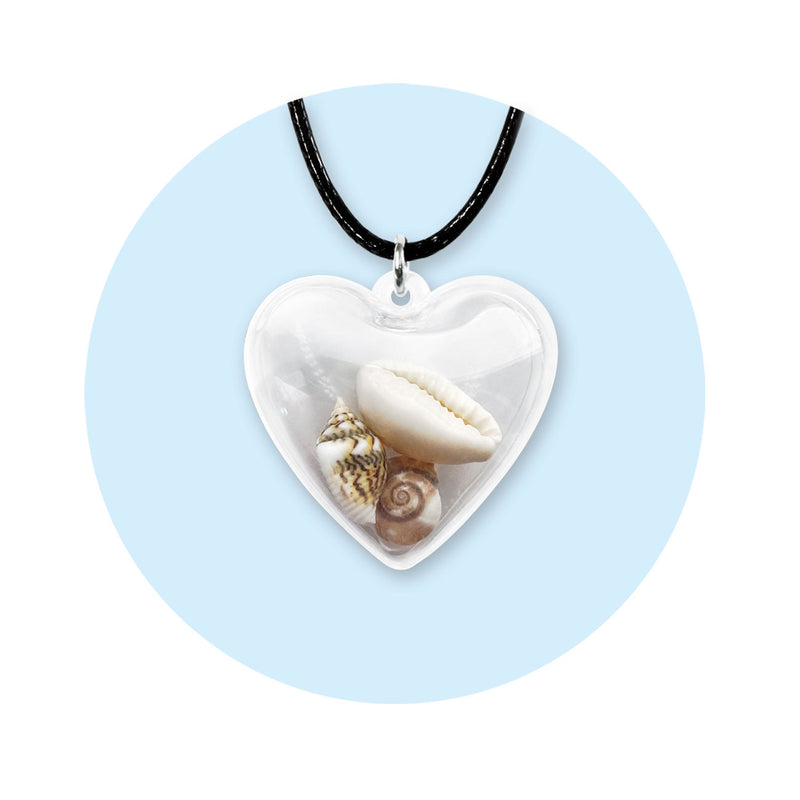 Clear heart locket necklace filled with 3 beach shells – cowrie and spiral shells on black cord