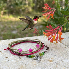 Show your love for hummingbirds with a cheerful four-piece bracelet stack featuring a silver-tone bird charm