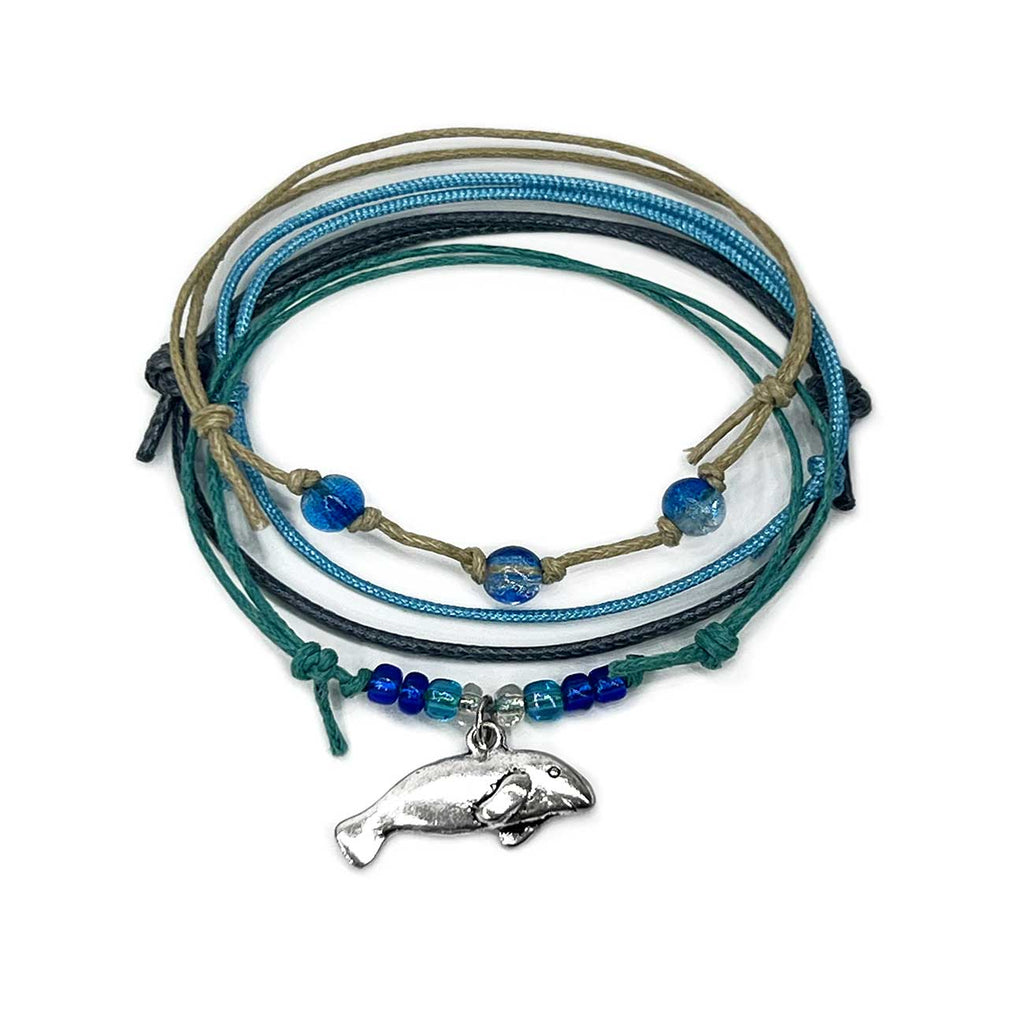 Manatee Bracelet Style Pack: 4 blue, turquoise and beige bracelets with a silver-tone manatee charm, flat lay on white
