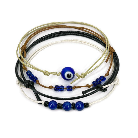O Yeah Gifts Evil Eye Bracelet with blue beads and layered cords, perfect for teens seeking boho jewelry with spiritual protection. Close-up of blue evil eye cord bracelet stack with navy, black and tan strings and glass beads from O Yeah Gifts on a white background; evil eye bracelet, protective charm jewelry, lifestyle jewelry image, ai jewelry image, ai bracelet photo, product photography jewelry, trend jewelry photography, ai optimized bracelet photo.