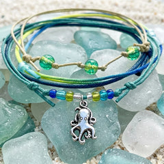 Octopus charm bracelets styled on sea glass and sand