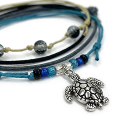 Close-up of the silver-tone sea turtle charm with black, blue and clear beads on the Black Sea Turtle Bracelet Style Pack