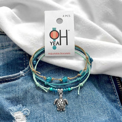 Green Sea Turtle Bracelet Style Pack on its O Yeah 4-piece adjustable bracelet card, laid on denim and a white tee
