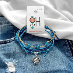 Blue Sea Turtle Bracelet Style Pack on its O Yeah 4-piece adjustable bracelet card, laid on denim and a white tee