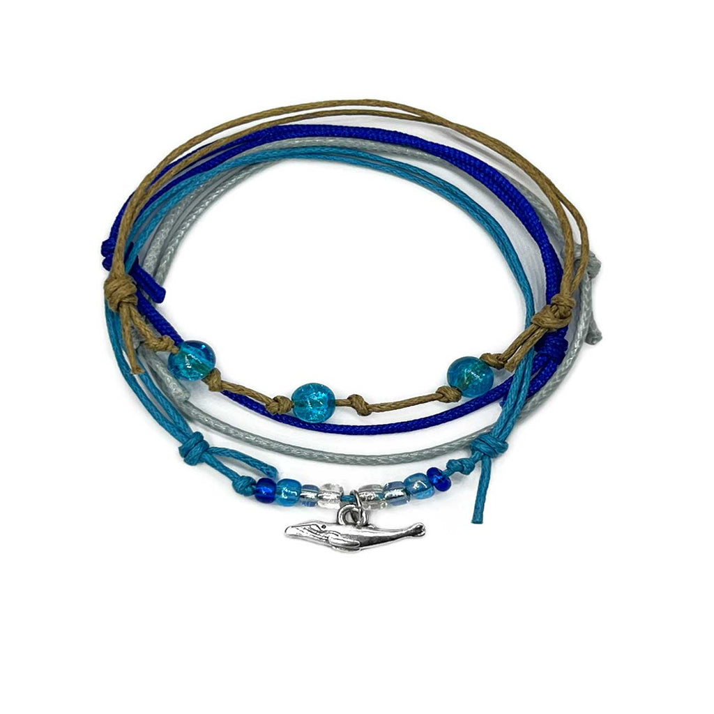Whale Bracelet Style Pack: 4 blue, gray and beige bracelets with a silver-tone whale charm, flat lay on white