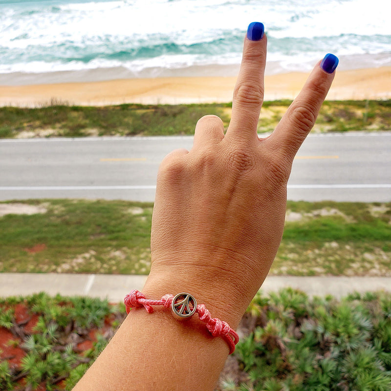 O Yeah Gifts Peace Charm Bracelet – Pink cord bracelet with a peace symbol charm, perfect for adding a touch of hippie style and groovy vibes to any outfit.