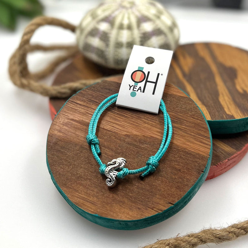 O Yeah Gifts Seahorse Bracelet – Display of a turquoise cord bracelet with a silver seahorse charm, adding a beachy touch to any outfit.