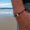 O Yeah Gifts Skull Charm Bracelet – Silver skull on black cord worn at the beach, bringing edgy style and attitude to any seaside look.