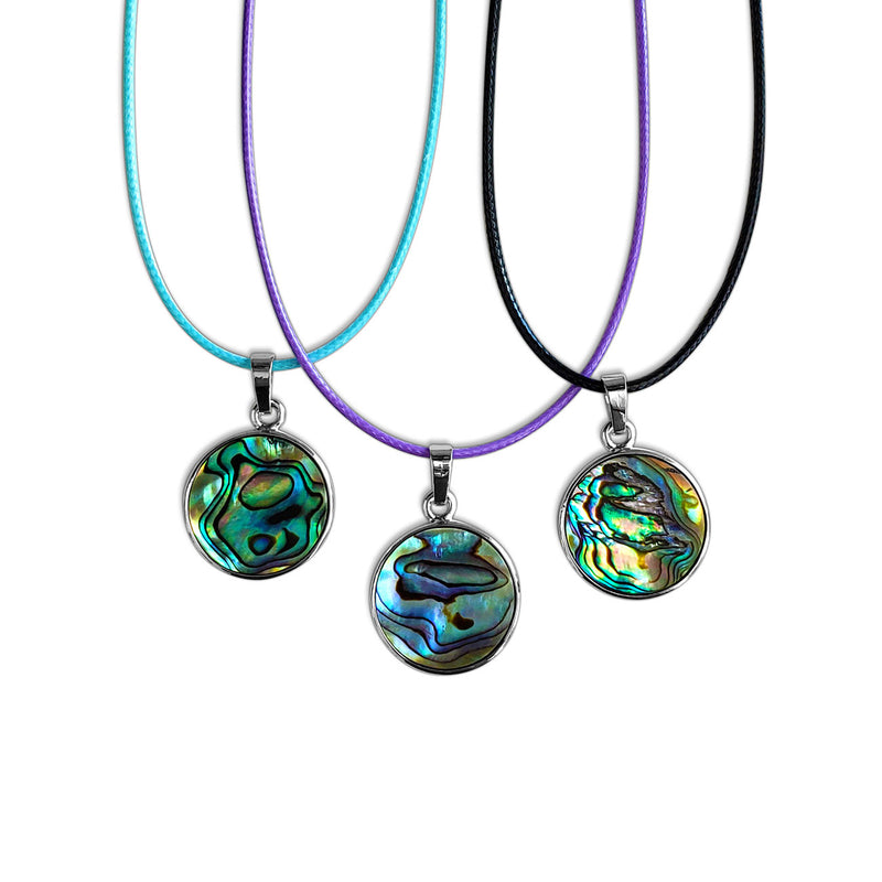Abalone shell necklace styled with layered chains for a beach-inspired look.